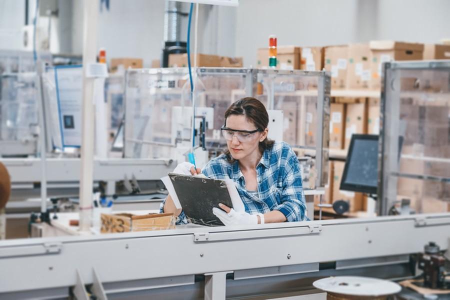 Kobieta z tabletem wśród maszyn produkcyjnych